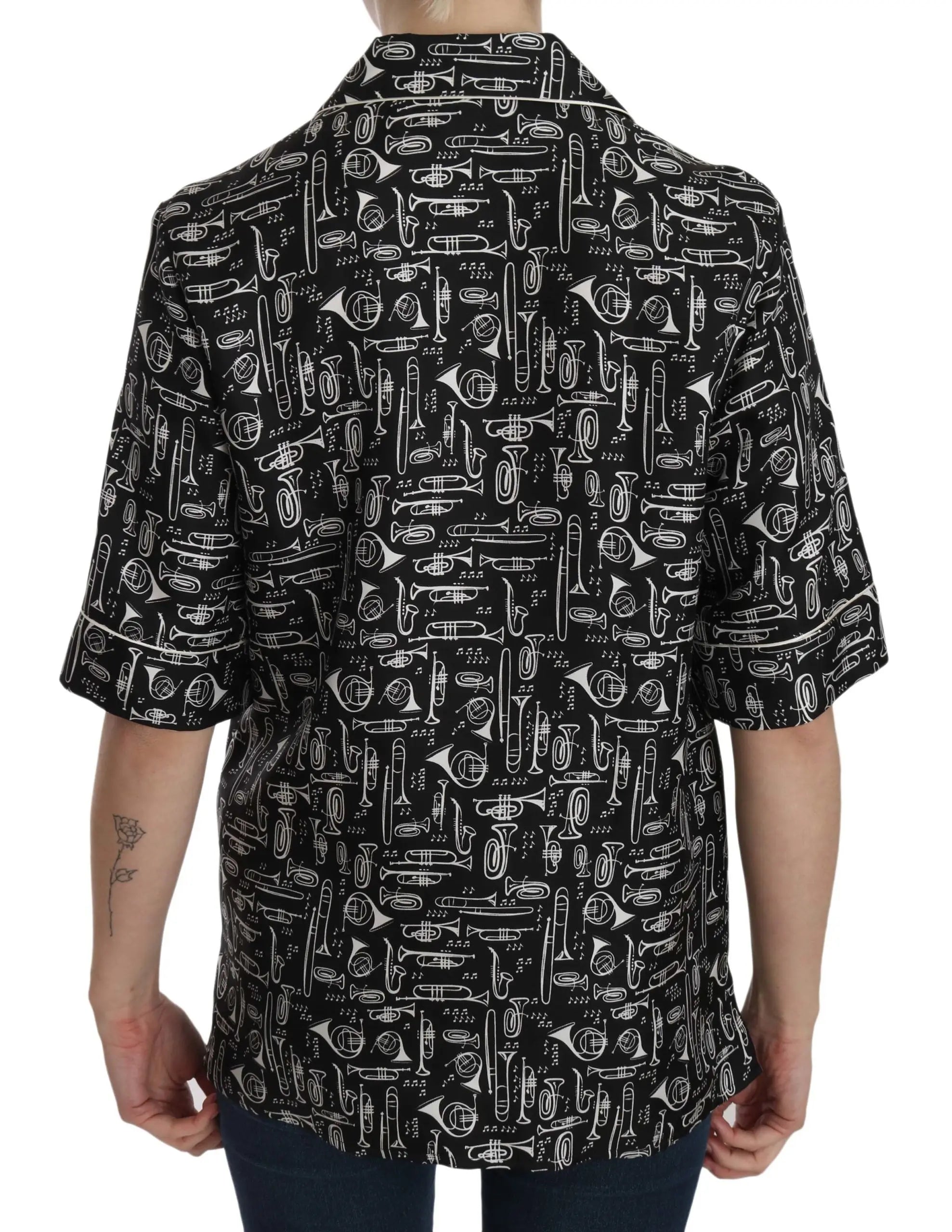 Black short-sleeve silk blouse with white musical instrument print and notched collar.