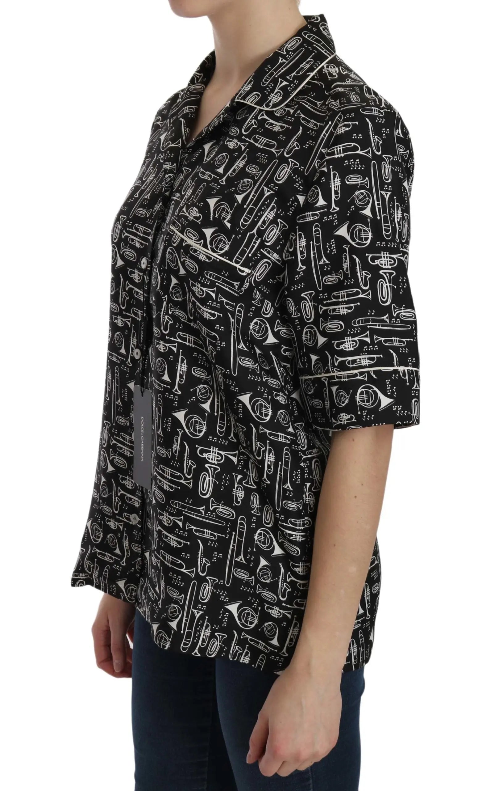 Black short-sleeve silk blouse with white musical instrument print and notched collar.