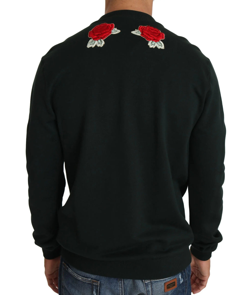 Green crewneck sweater with embroidered crystal heart, roses, and gun motifs.