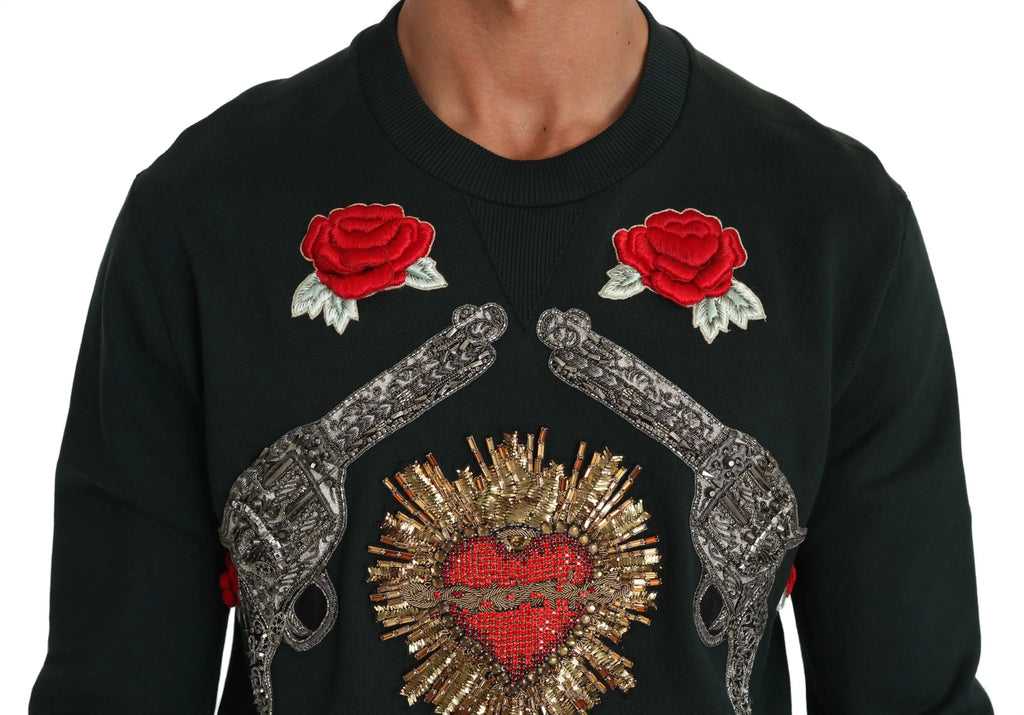 Green crewneck sweater with embroidered crystal heart, roses, and gun motifs.