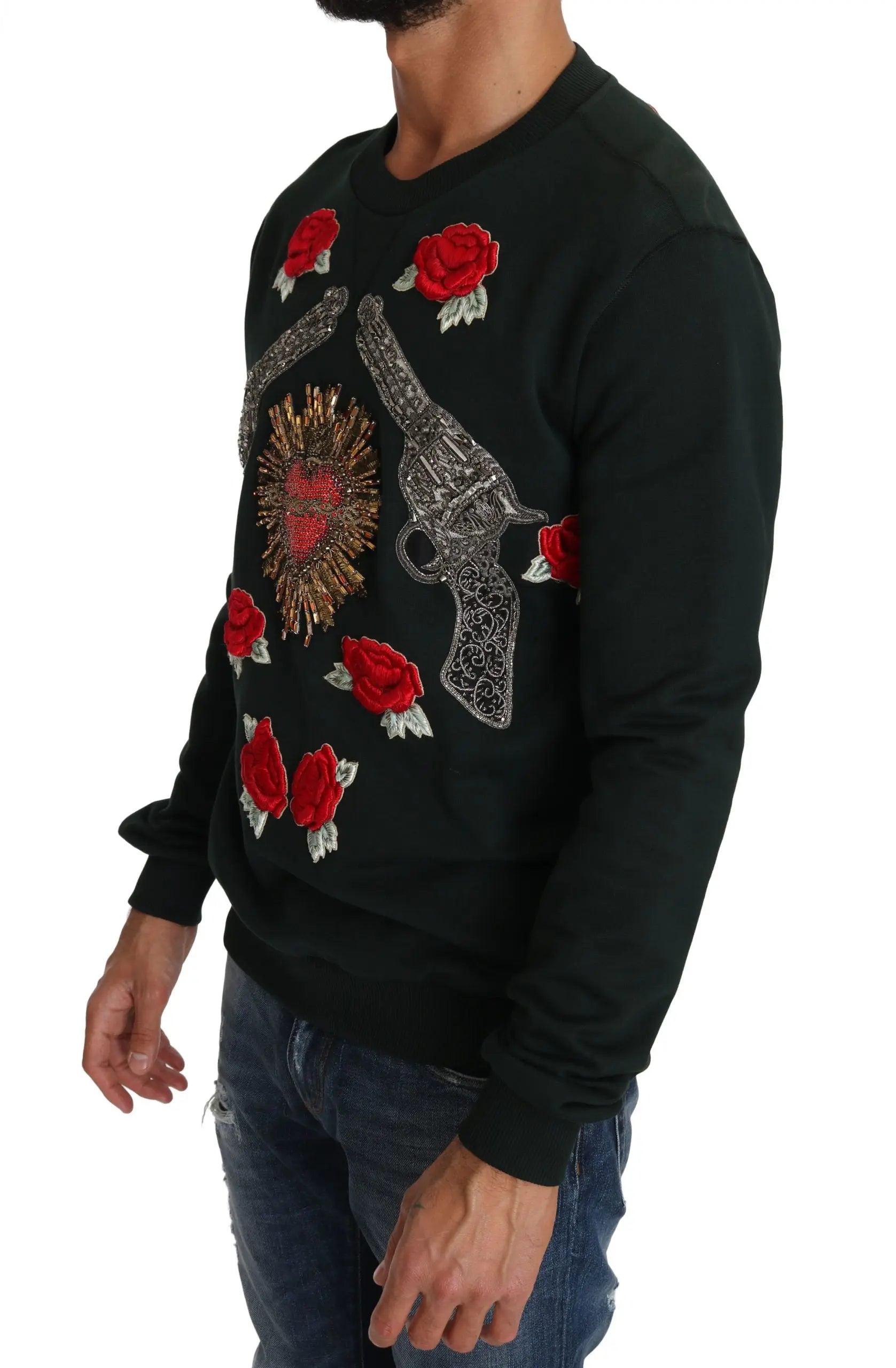 Green crewneck sweater with embroidered crystal heart, roses, and gun motifs.