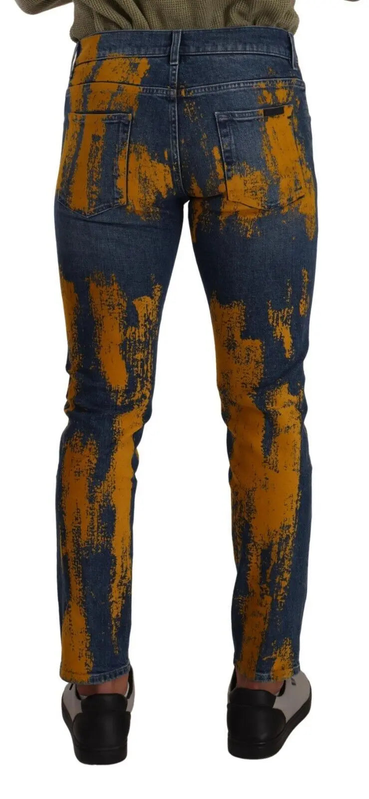 Men’s skinny denim jeans in blue with bold yellow dye splatter, button and zip front closure.