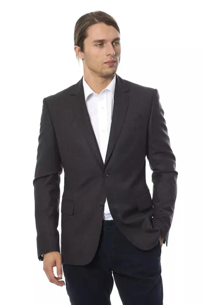Men's dark gray wool blazer with notch lapels and two-button closure, worn over white dress shirt.