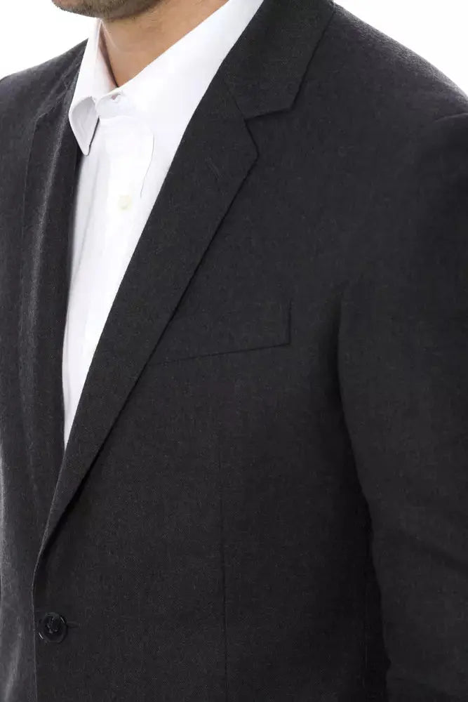 Men's dark gray wool blazer with notch lapels and two-button closure, worn over white dress shirt.