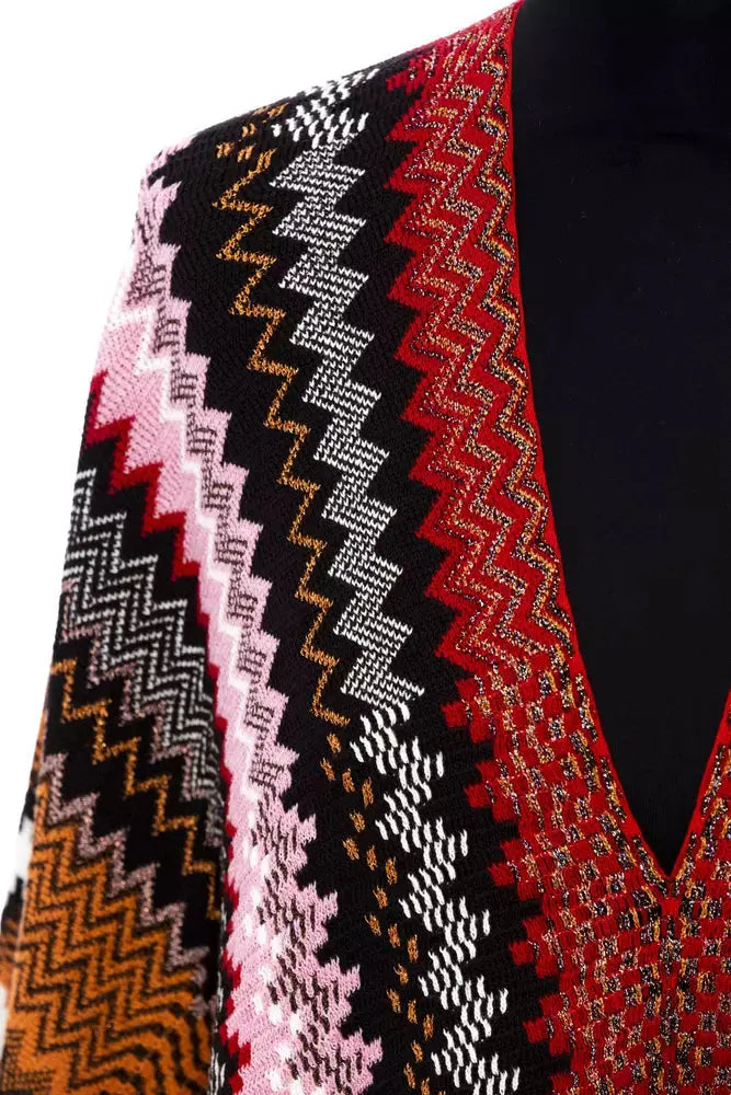 Multicolor wool poncho with zigzag pattern in pink, brown, black, white, and orange, fringed edges.