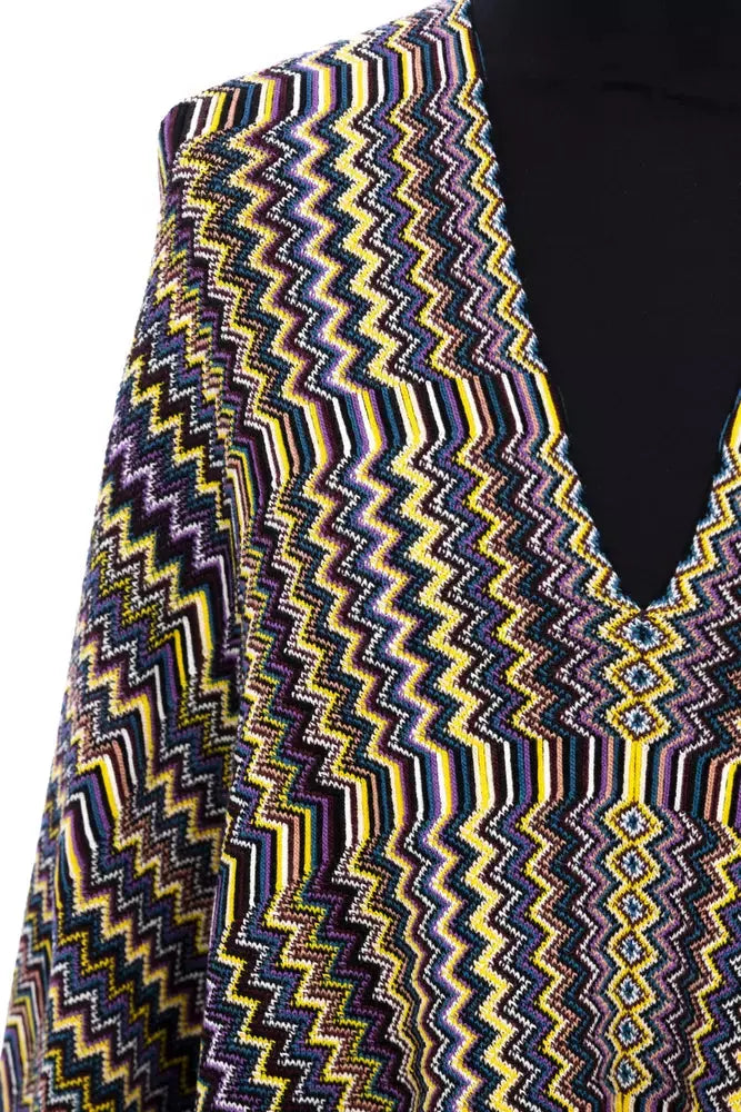 Multicolor wool poncho with zigzag pattern and fringe hem on black mannequin.