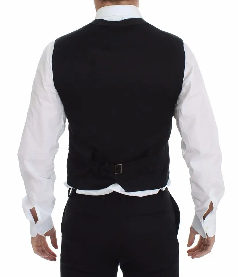 Black cotton viscose dress vest blazer with button front and pointed hem over white dress shirt and black tie.