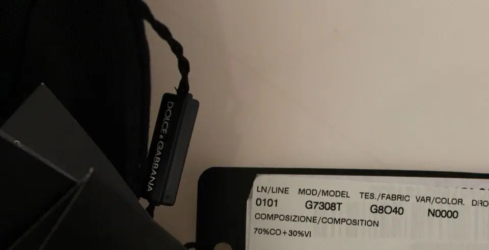 Black cotton viscose dress vest blazer with button front and pointed hem over white dress shirt and black tie.