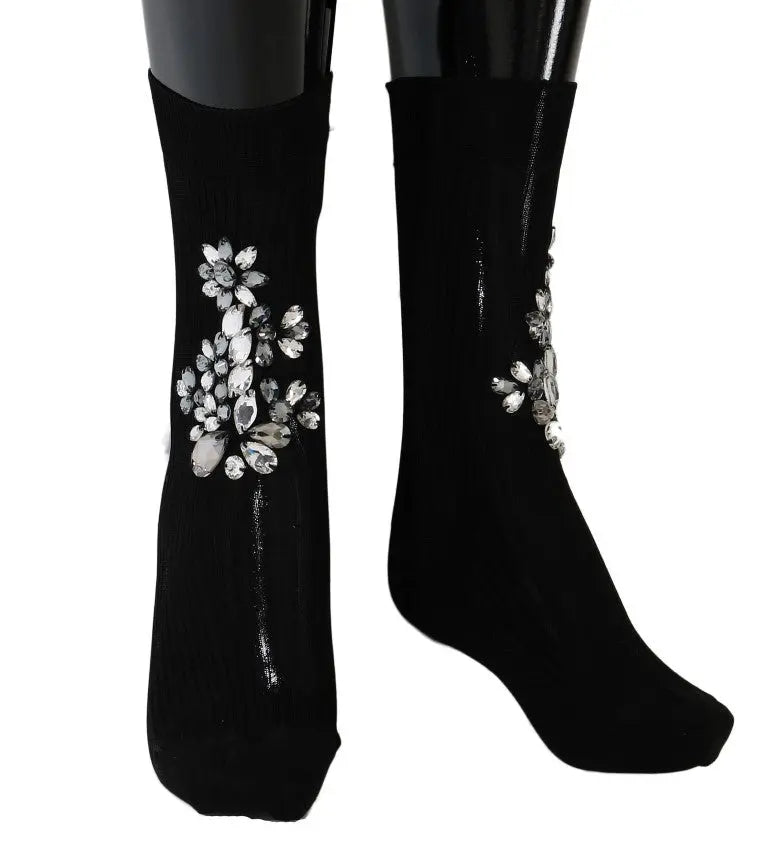 Black knitted socks with large clear crystal floral embellishments on the sides.
