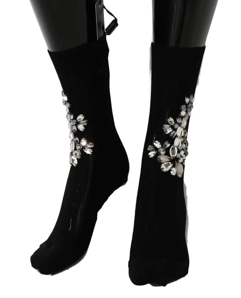 Black knitted socks with large clear crystal floral embellishments on the sides.