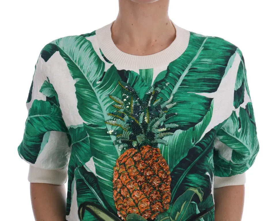White crewneck sweater with green tropical leaves and a large sequin pineapple embellishment on front.