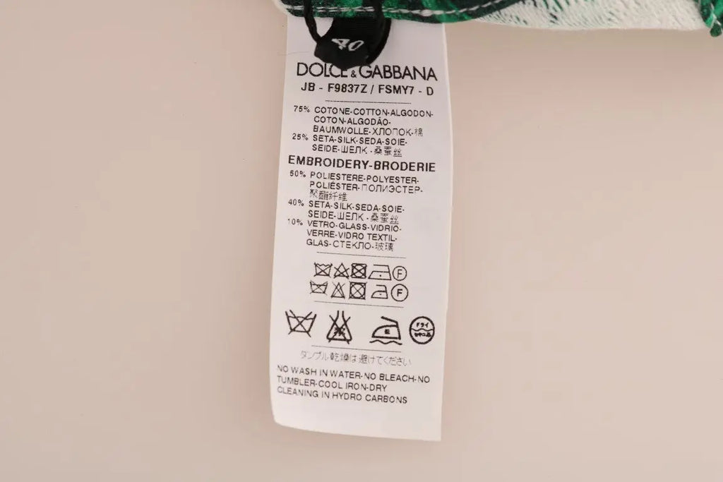 White crewneck sweater with green tropical leaves and a large sequin pineapple embellishment on front.