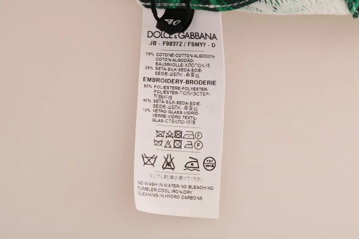 White crewneck sweater with green tropical leaves and a large sequin pineapple embellishment on front.