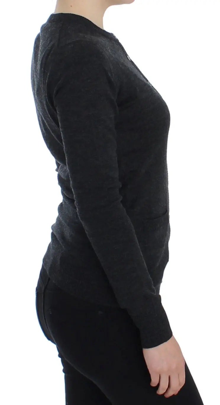 Dark gray wool button-up cardigan sweater with long sleeves and ribbed cuffs on a model.