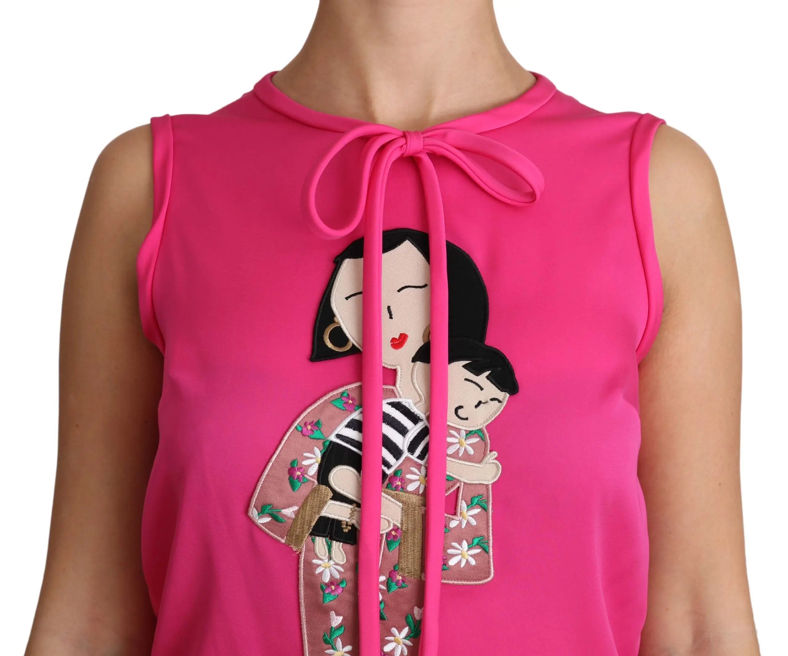 Pink sleeveless silk tank top with a bow tie neckline and colorful embroidered characters on the front.